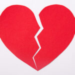 love concept – red paper broken heart over white background